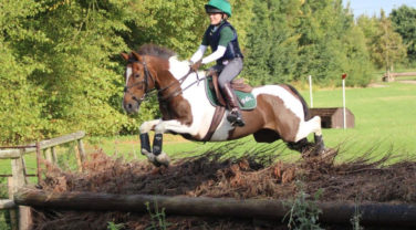 Maisie Randle and horse jumping cross country fence